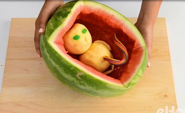 Insert the apple alien baby into the watermelon.